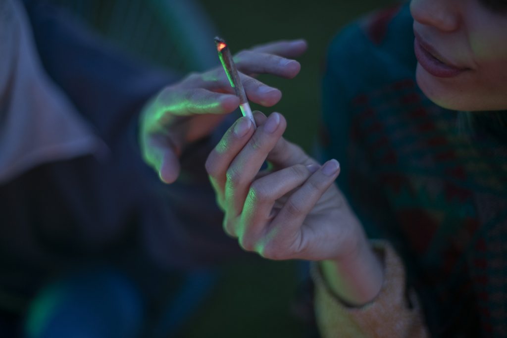 two lesbian women smoke marijuana, close up